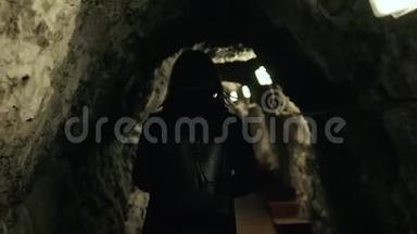 黑暗洞穴中的女人带着背包游客跟随。 后景。 石墙之间的<strong>编剧</strong>女孩。
